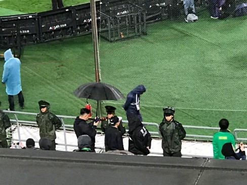 暖，工体球迷雨天为武警撑伞