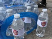 紧跟热点，曼城球迷在球场外出售贴有阿森纳队徽的水瓶