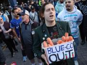 切尔西球迷手持胡萝卜抗议BlueCo，它象征着“空头支票”